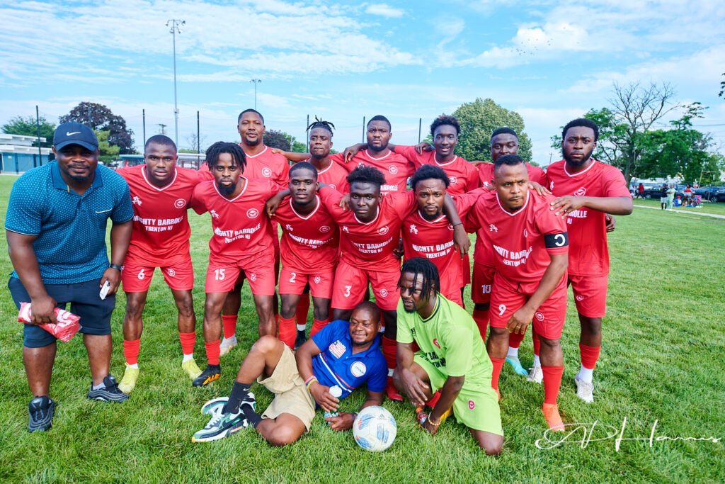 Soccer team in red jerseys posing on the field during the July 2023 Independence Day sporting events